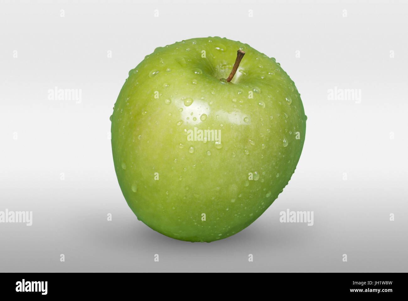 Tasty green apple with drops on white background in front view with ...