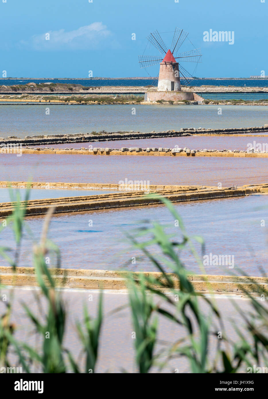 Saltpans and windmills in the Stagnone lagoon between Marsala and Trapani, on the west coast of Sicily, Italy. Stock Photo
