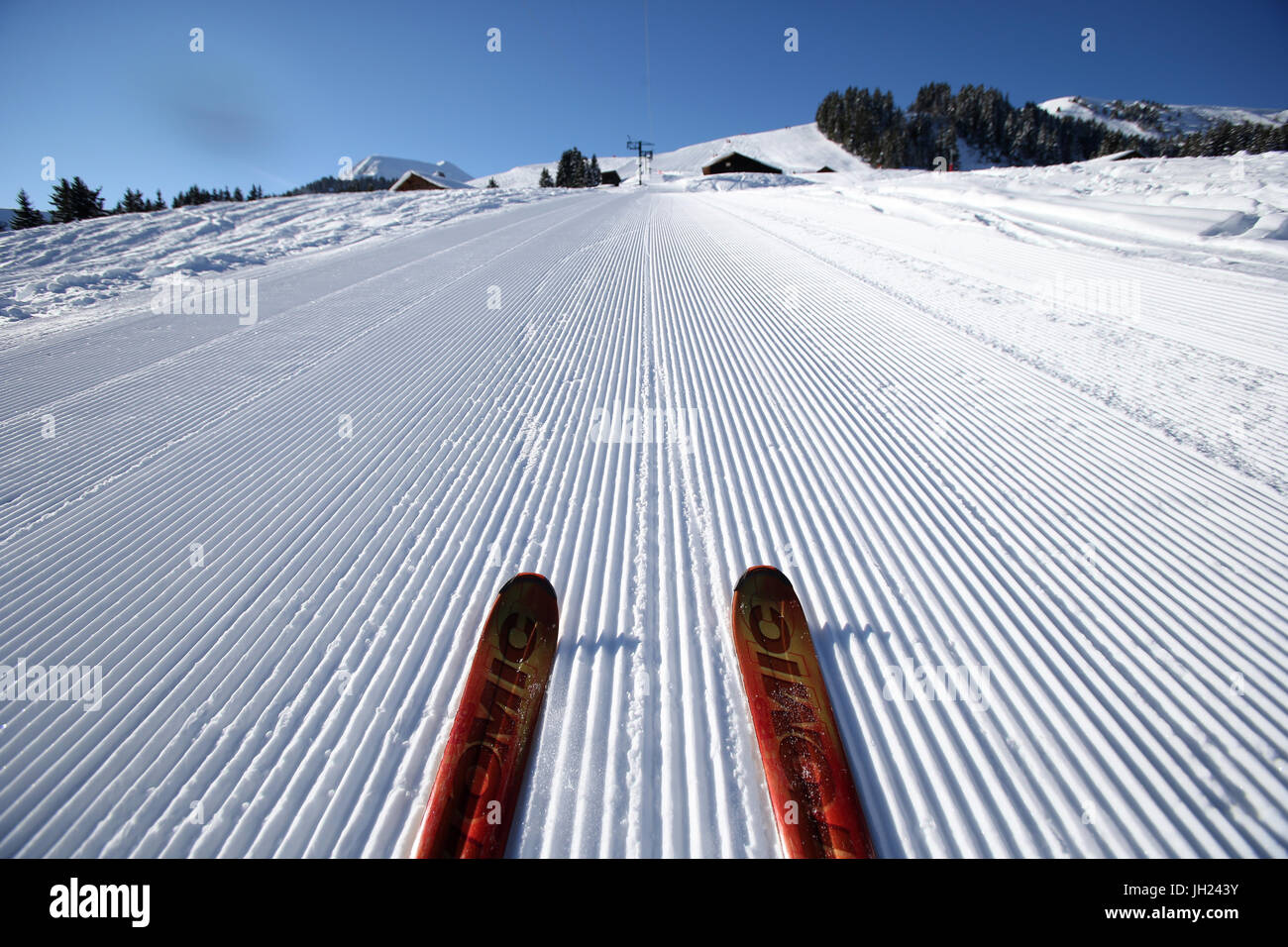 French Alps. Red pair of ski in snow. Groomed Ski Piste. France. Stock Photo
