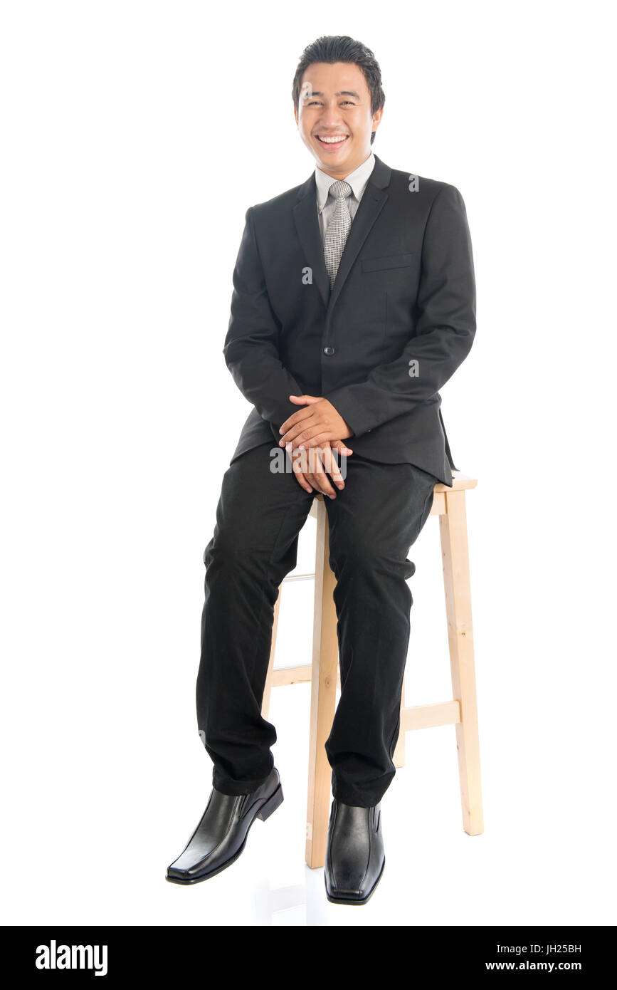 Full body portrait of happy young Southeast Asian businessman sitting ...