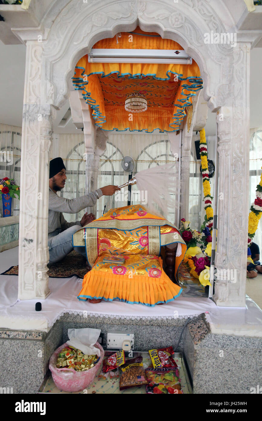 Gurdwara Sahib Silat Road ( Silat Road Sikh Temple ).  Bhai Maharaj Singh Memorial.  Tha Palki.   Guru Granth Sahib sikh holy book.  The Sevadar (volu Stock Photo