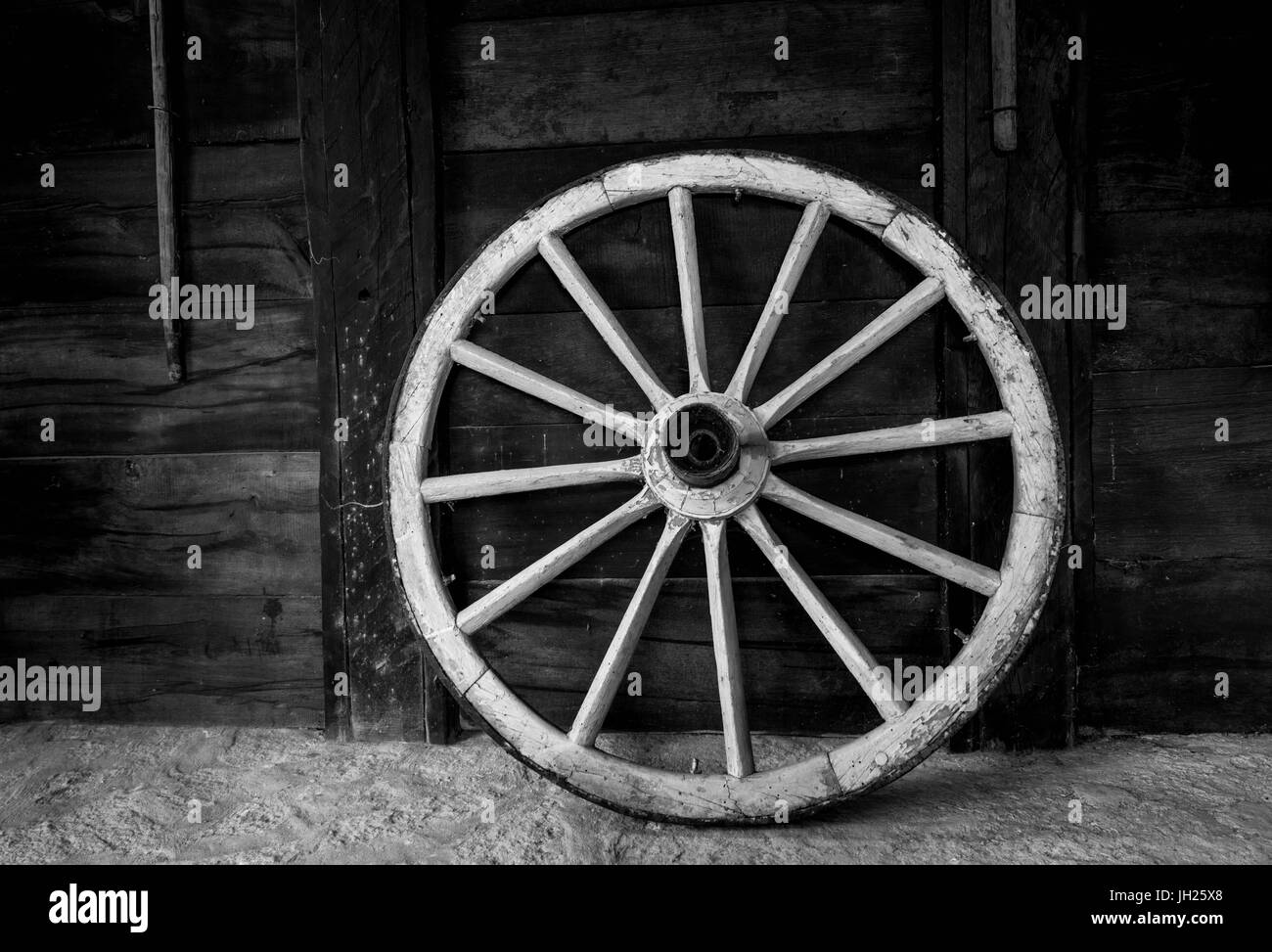 A wagon wheel propped against a wall Stock Photo Alamy