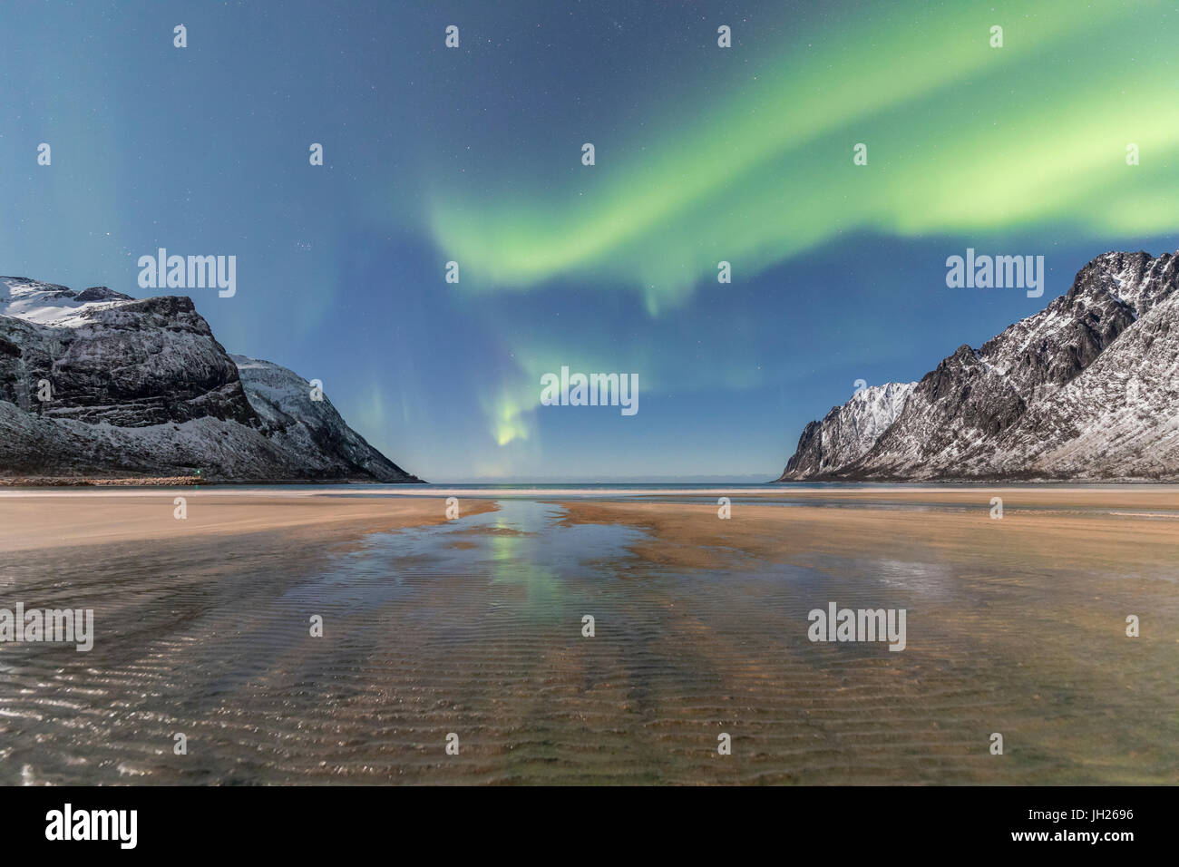 Sandy beach and snowy peaks framed by the Northern Lights in the polar night, Ersfjord, Senja, Troms, Norway Stock Photo