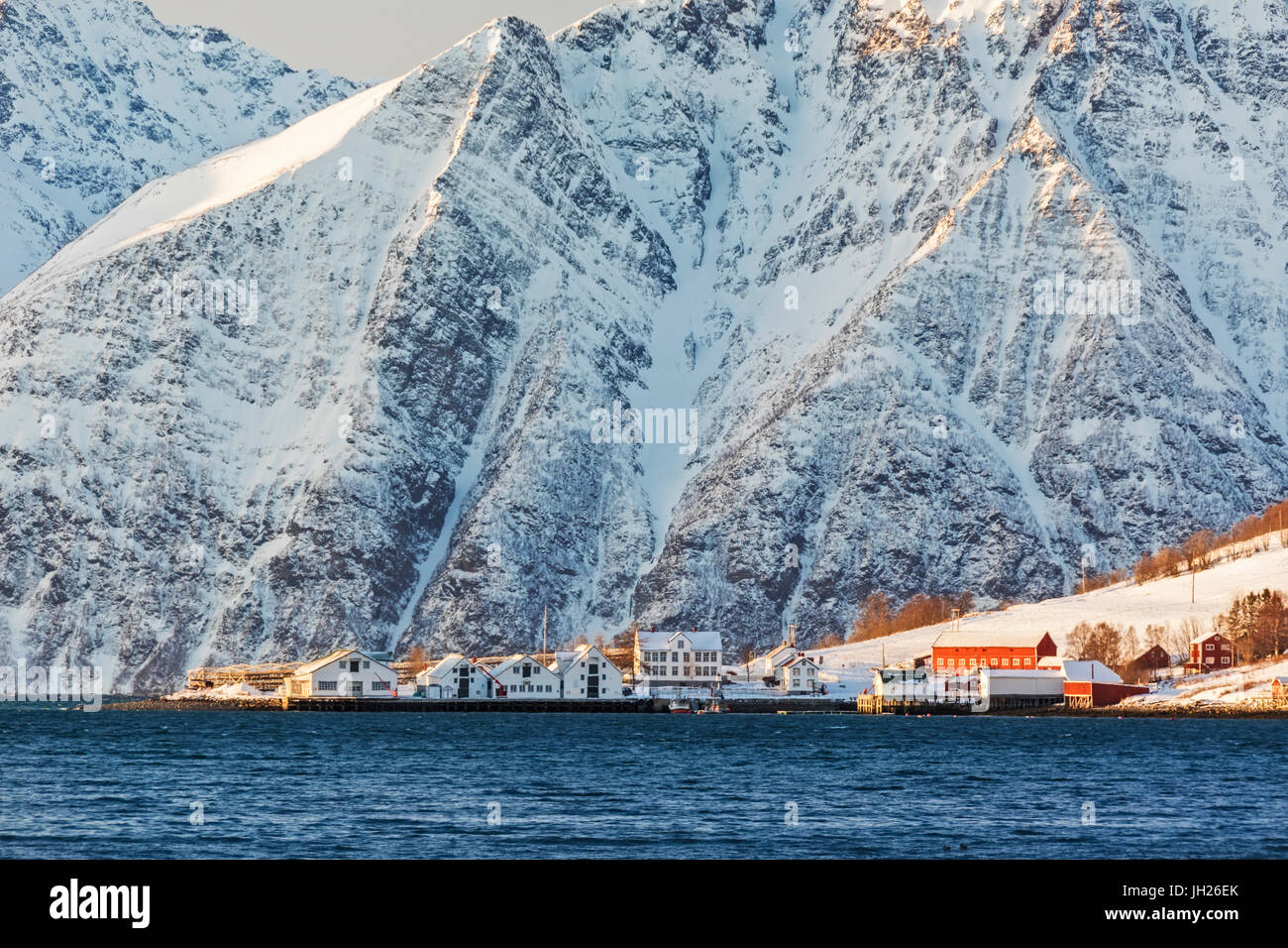 The typical fishing village of Hamnes framed by snowy peaks and the cold sea, Lyngen Alps, Troms, Norway, Scandinavia, Europe Stock Photo