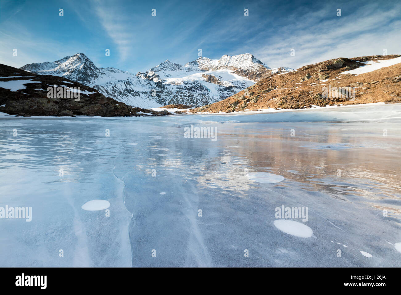 Blue sky on the frozen Lej Nair surrounded by snowy peaks, Bernina Pass, Canton of Graubunden, Engadine, Switzerland, Europe Stock Photo