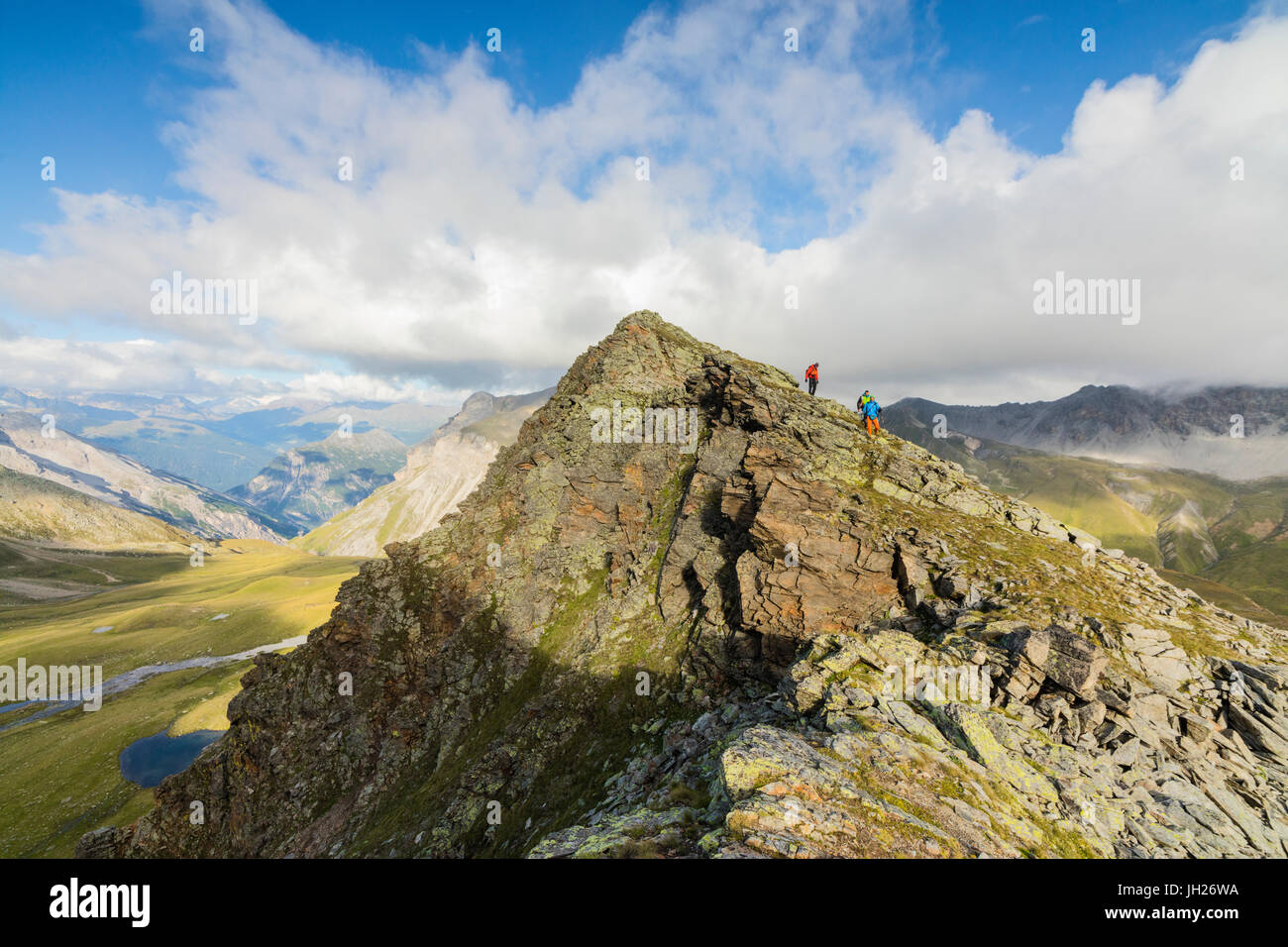 Hikers on the rocky crest of Monte Scorluzzo in summer, Bormio, Braulio Valley, Stelvio Pass, Valtellina, Lombardy, Italy Stock Photo
