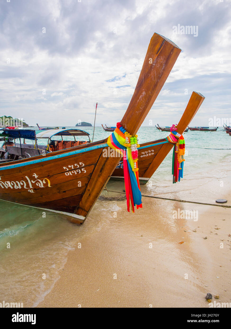 Long-tail boats with coloured-ribbon offerings, Ko Lipe, Thailand, Southeast Asia, Asia Stock Photo