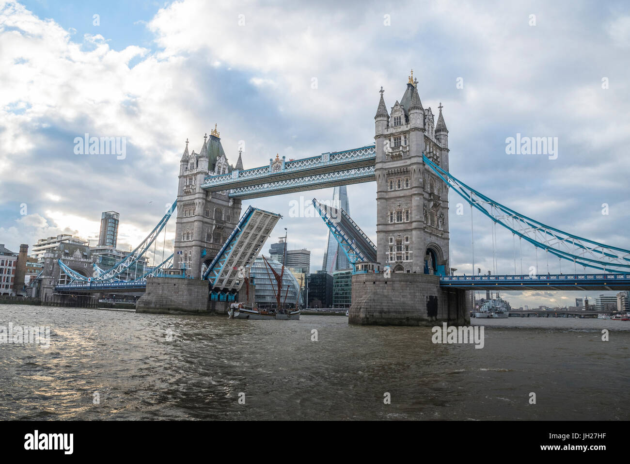 Tower Bridge raised with tall ship passing through with London's City ...