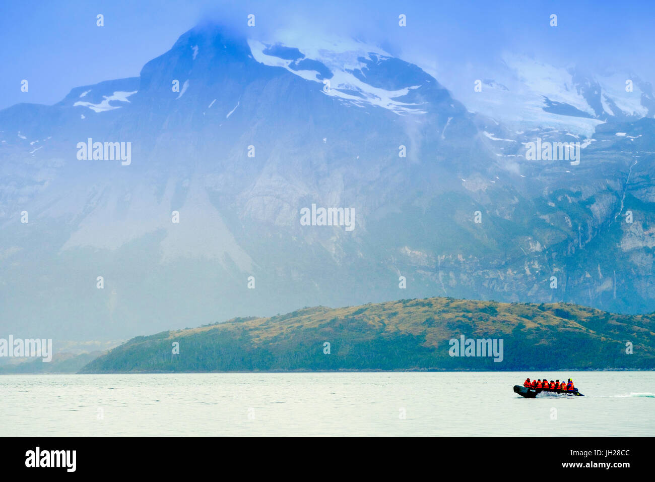 Dingy in a fjord in Alberto de Agostini National Park with the Darwin mountain range behind, Patagonia, Chile Stock Photo