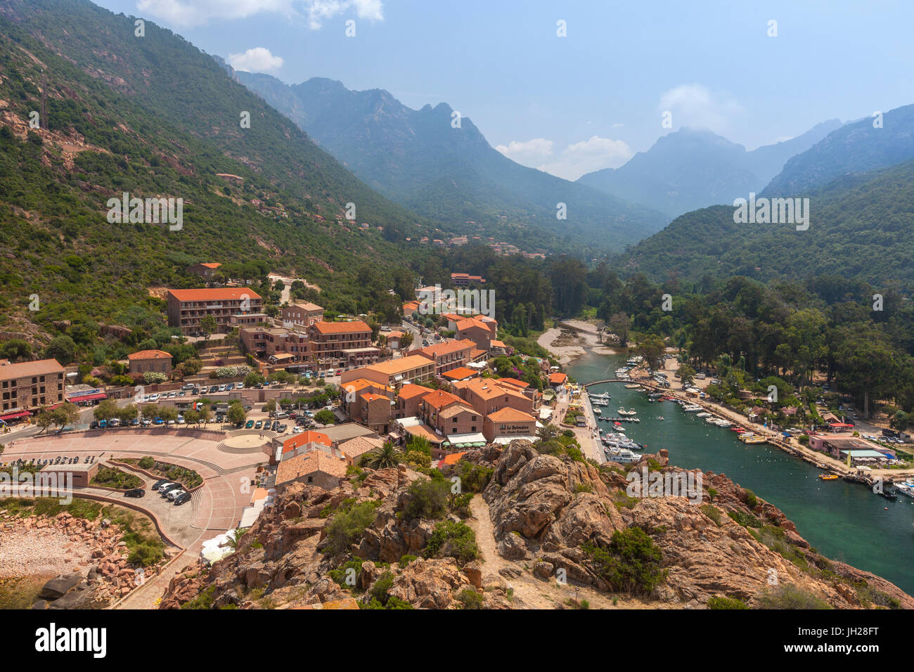 The typical village and harbor of Porto immersed in the green vegetation of the promontory, Southern Corsica, France Stock Photo