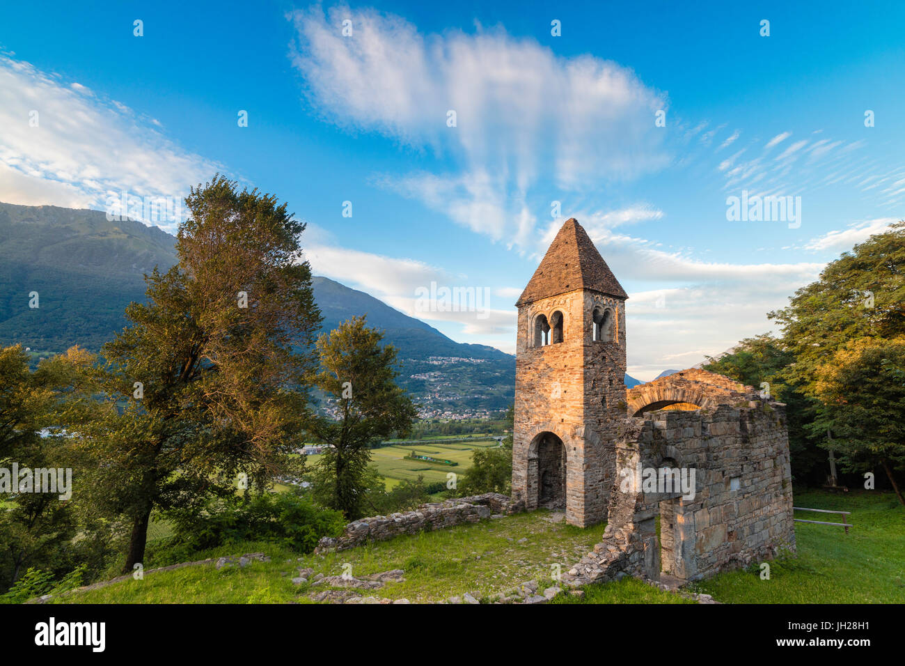 Sunset sky frames the ancient Abbey of San Pietro in Vallate, Piagno, Sondrio province, Lower Valtellina, Lombardy, Italy Stock Photo