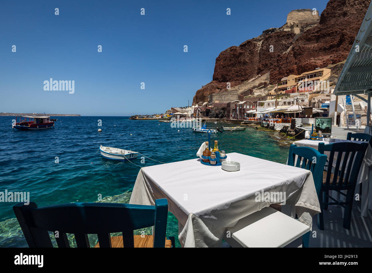 A table with a view at one of the seafood restaurants in Ammoudi Bay, below Oia, Santorini, Cyclades, Greek Islands, Greece Stock Photo