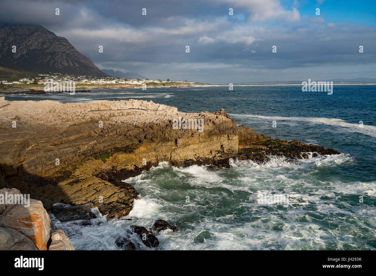 Seascape across stormy sea and rocks in setting sun at Sievers Point, Hermanus, South Africa, Africa Stock Photo