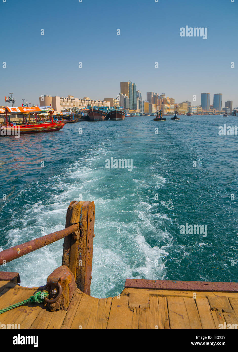 Modern Dubai cityscape disappears in the wake of an old water taxi speeding, Dubai, United Arab Emirates Stock Photo
