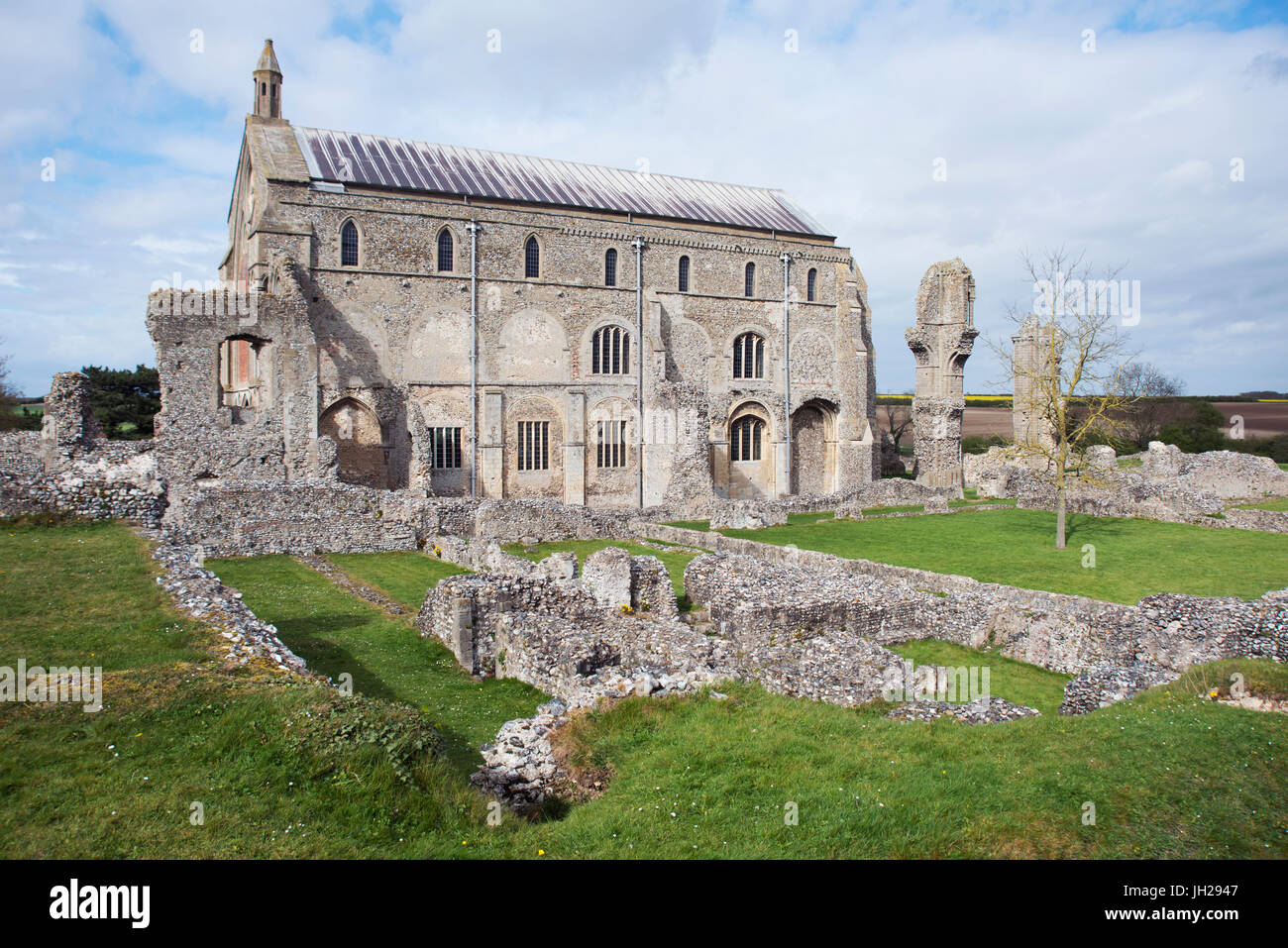 The grounds of the ruined Benedictine Priory of Binham Abbey, with the existing church behind, North Norfolk, England, UK Stock Photo