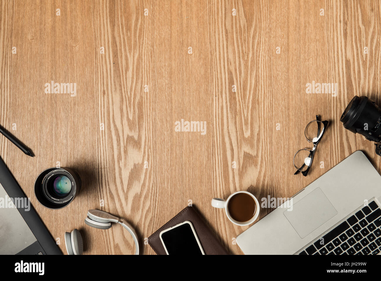 Work space for photographer, graphic designer. Flat lay of laptop, camera, colorchart, digital tablet, coffee cup, book, pencil on wooden table. Stock Photo