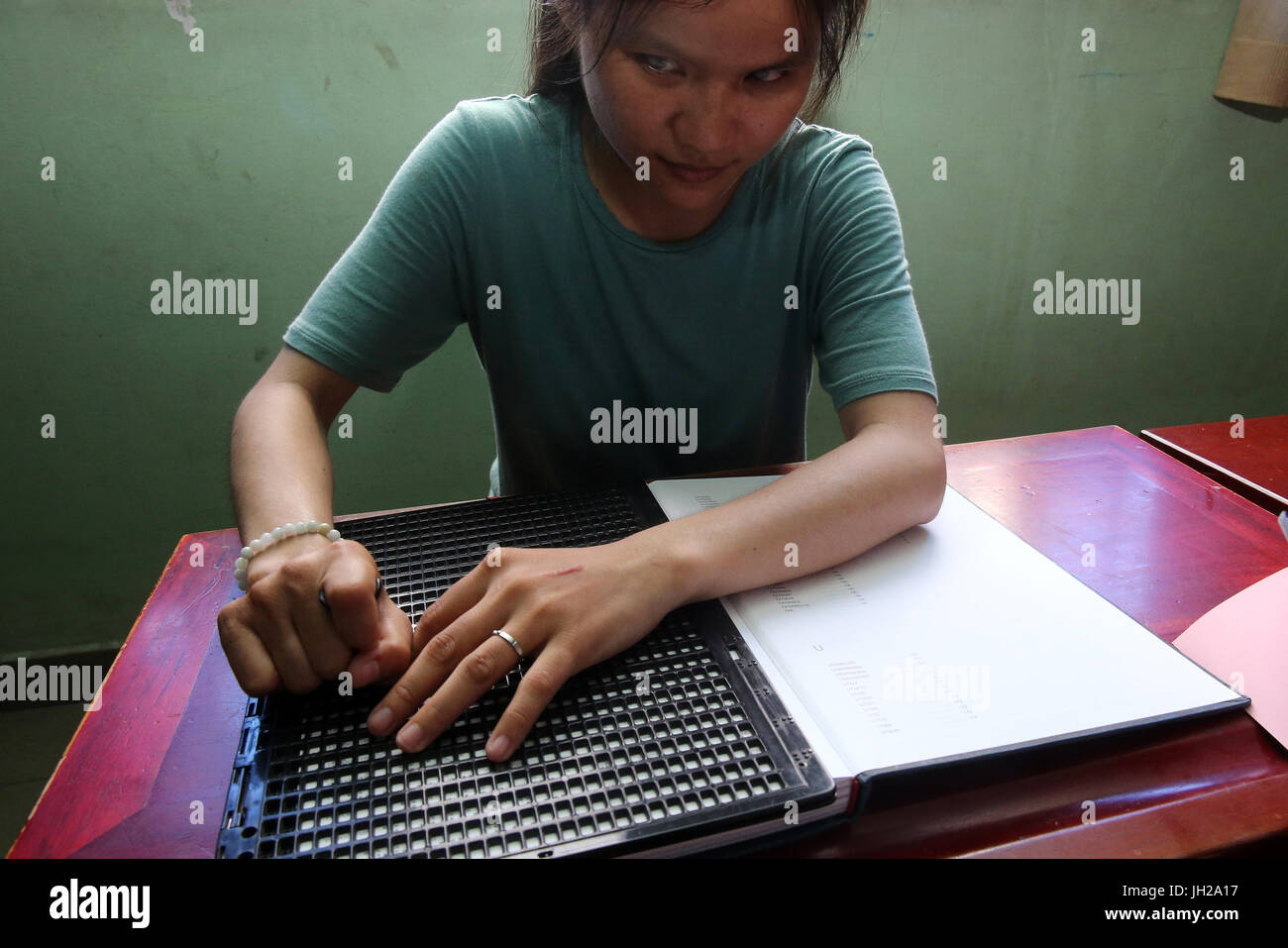 Vietnam.  Center for blind children.  Girl writing braille. Stock Photo