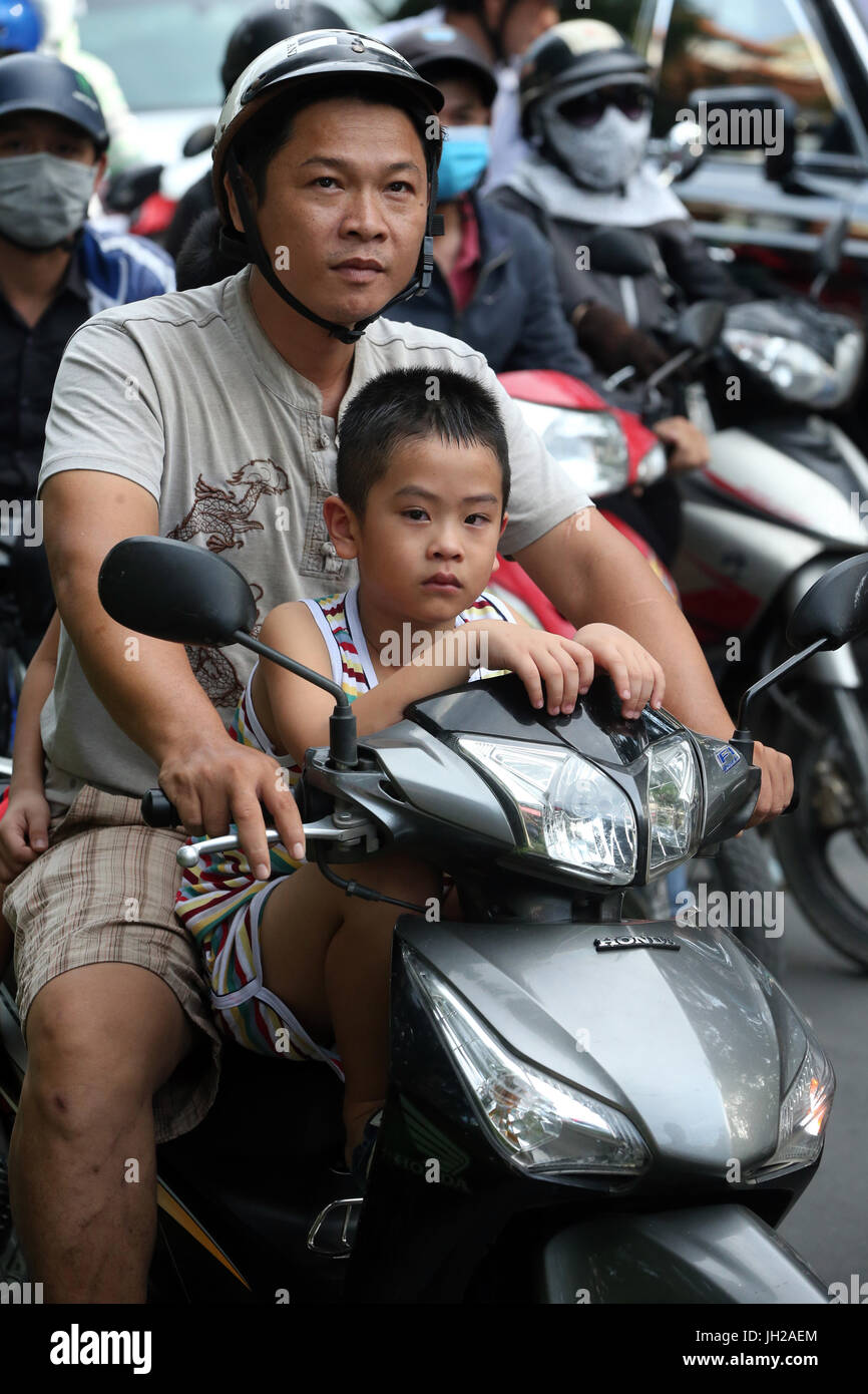 Vietnamese family  riding a motorcycle on Saigon Street.  Vietnam. Stock Photo