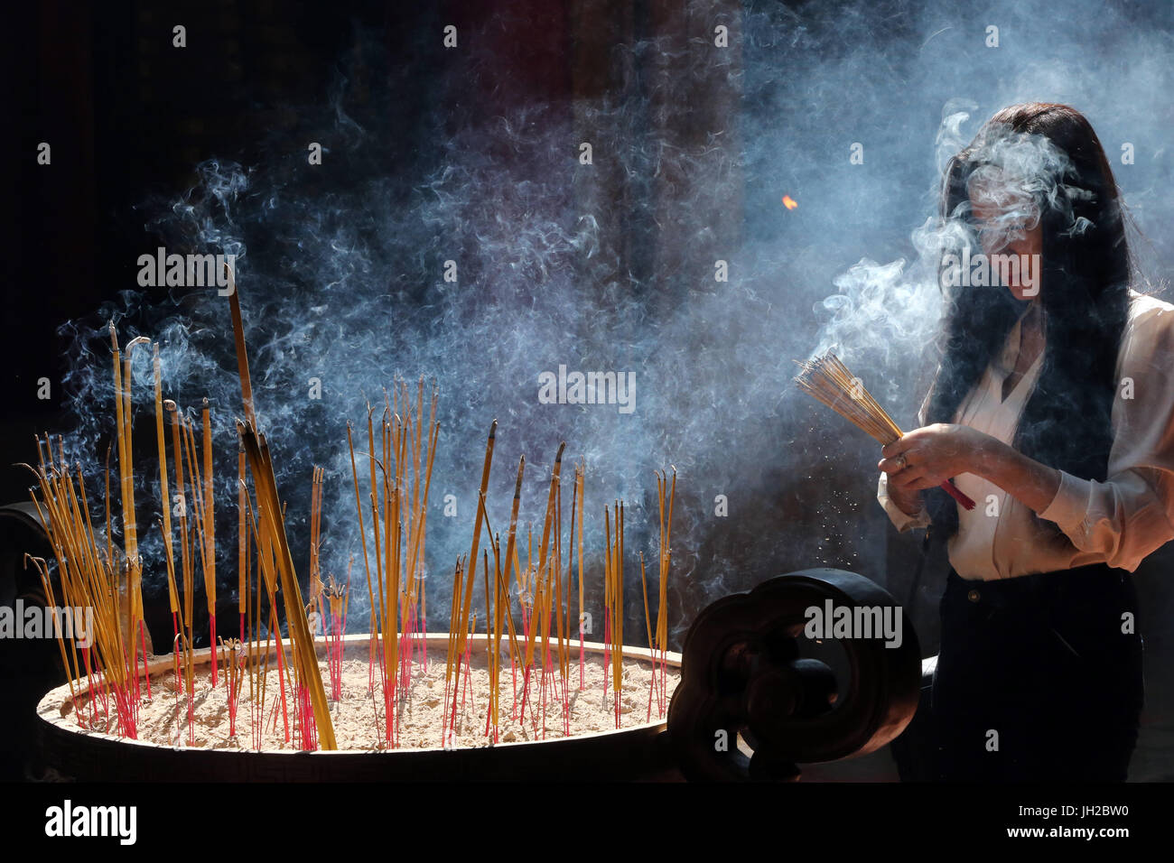 Buddhist worshipper burning incense sticks hi-res stock photography and ...
