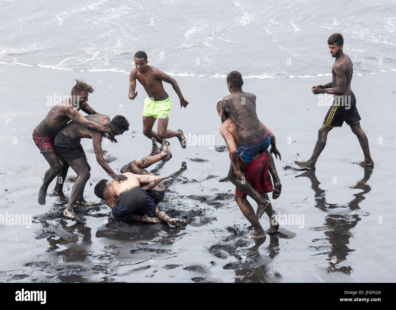 Spanish teenagers fun fighting on beach Stock Photo