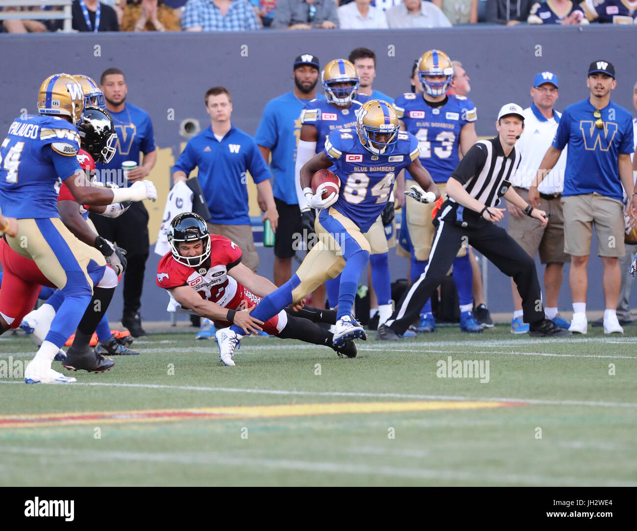 Winnipeg, Manitoba, CAN. 7th July, 2017. July 7, 2017; Winnipeg, Manitoba, CAN; Winnipeg Blue Bombers wide receiver Ryan Lankford (84) steps past a diving Calgary Stampeders kicker Rene Paredes (30) during the first half at Investors Group Field. Mandatory Credit: Bruce Fedyck- Zuma Media Credit: Bruce Fedyck/ZUMA Wire/Alamy Live News Stock Photo