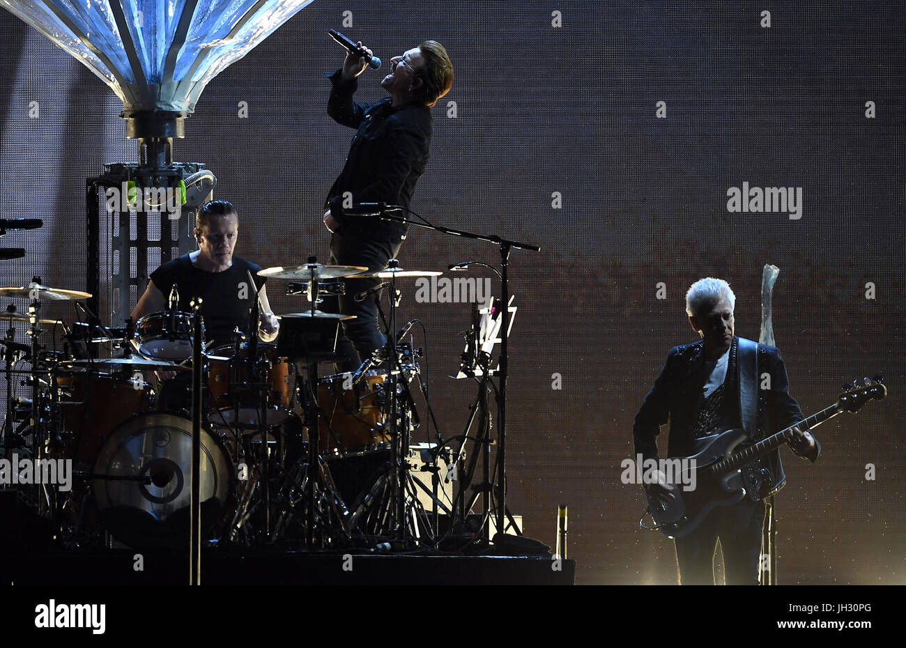 Berlin, Germany. 12th July, 2017. Musicians (l-r), Larry Mullen junior, Paul David Hewson (Bono) and Adam Clayton of the Irish band U2 on stage at the Olympic Stadium in Berlin, Germany, 12 July 2017. Photo: Britta Pedersen/dpa-Zentralbild/dpa/Alamy Live News Stock Photo