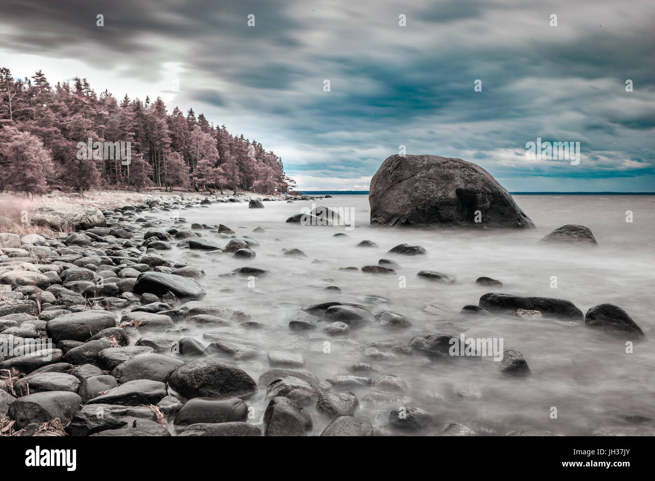 Baltic sea shore with boulders. Infrared color swapped photograph. Stock Photo