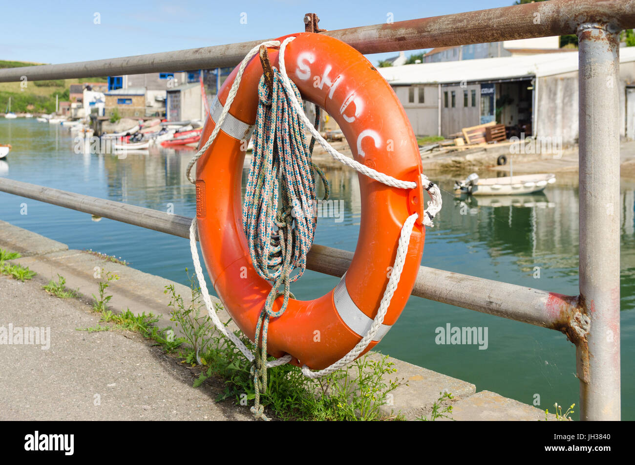 Lifebuoy attached to railings on the waters edge at Shadycombe in Salcombe, South Hams, Devon Stock Photo