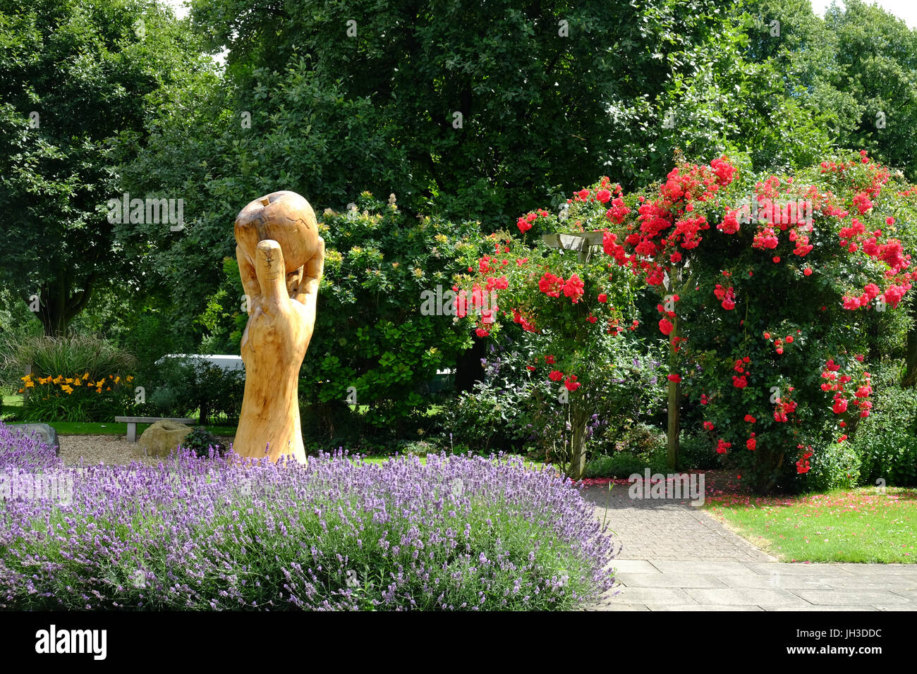 Wooden sculpture of sir Isaac Newton's hand and apple in Wyndham Park, Grantham, Lincolnshire, England, UK Stock Photo