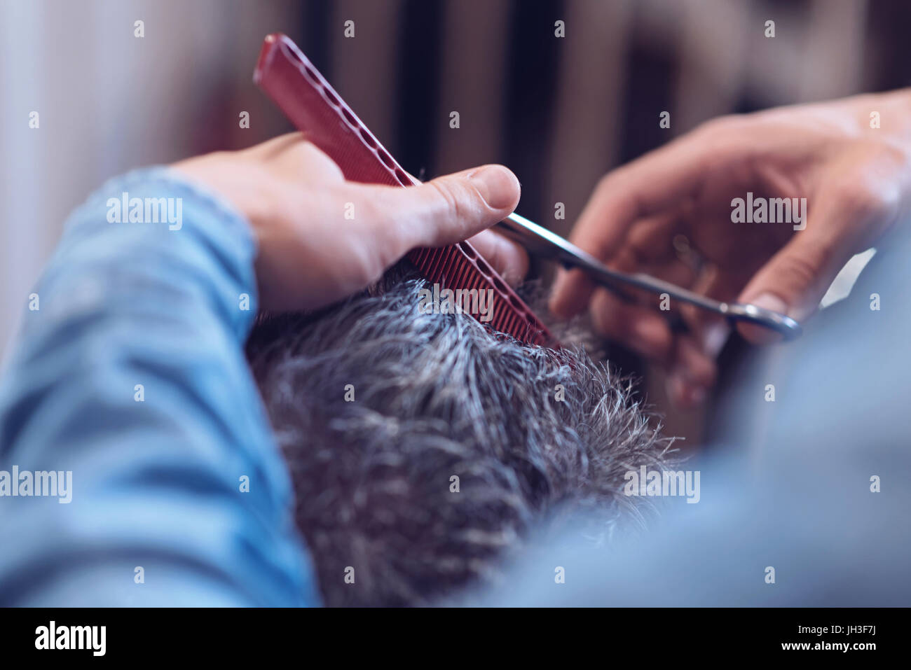 Red comb being used by a barber Stock Photo Alamy
