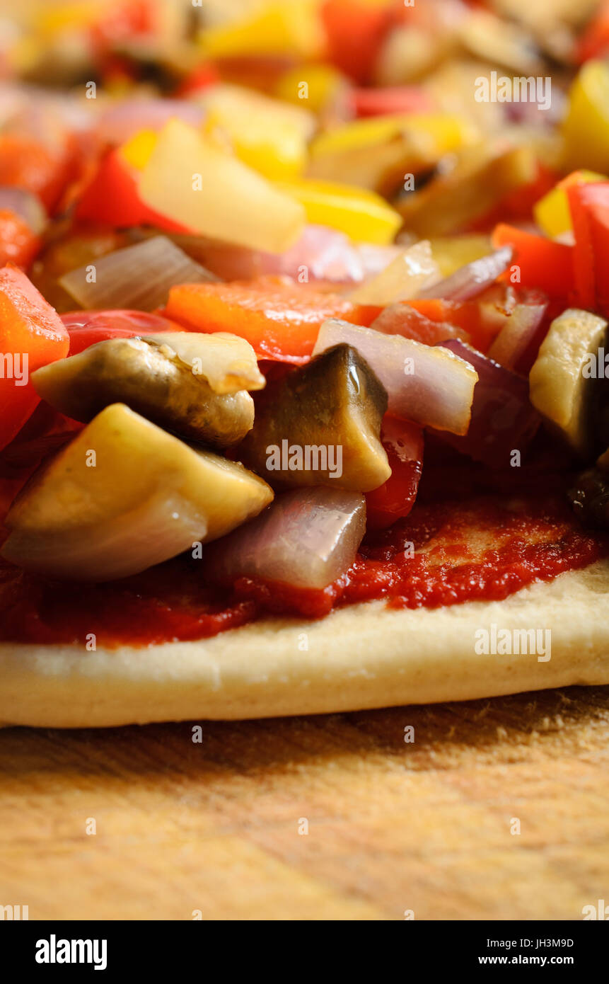 Close up (macro) of a pizza at pre-baked stage, topped sauteed vegetables. Stock Photo