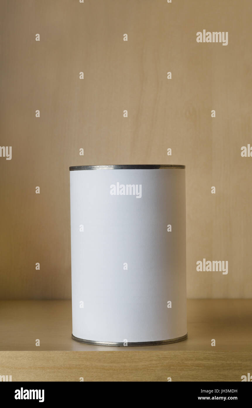 One single tin can (aluminum) with blank white label on shelf with copy space above. Stock Photo