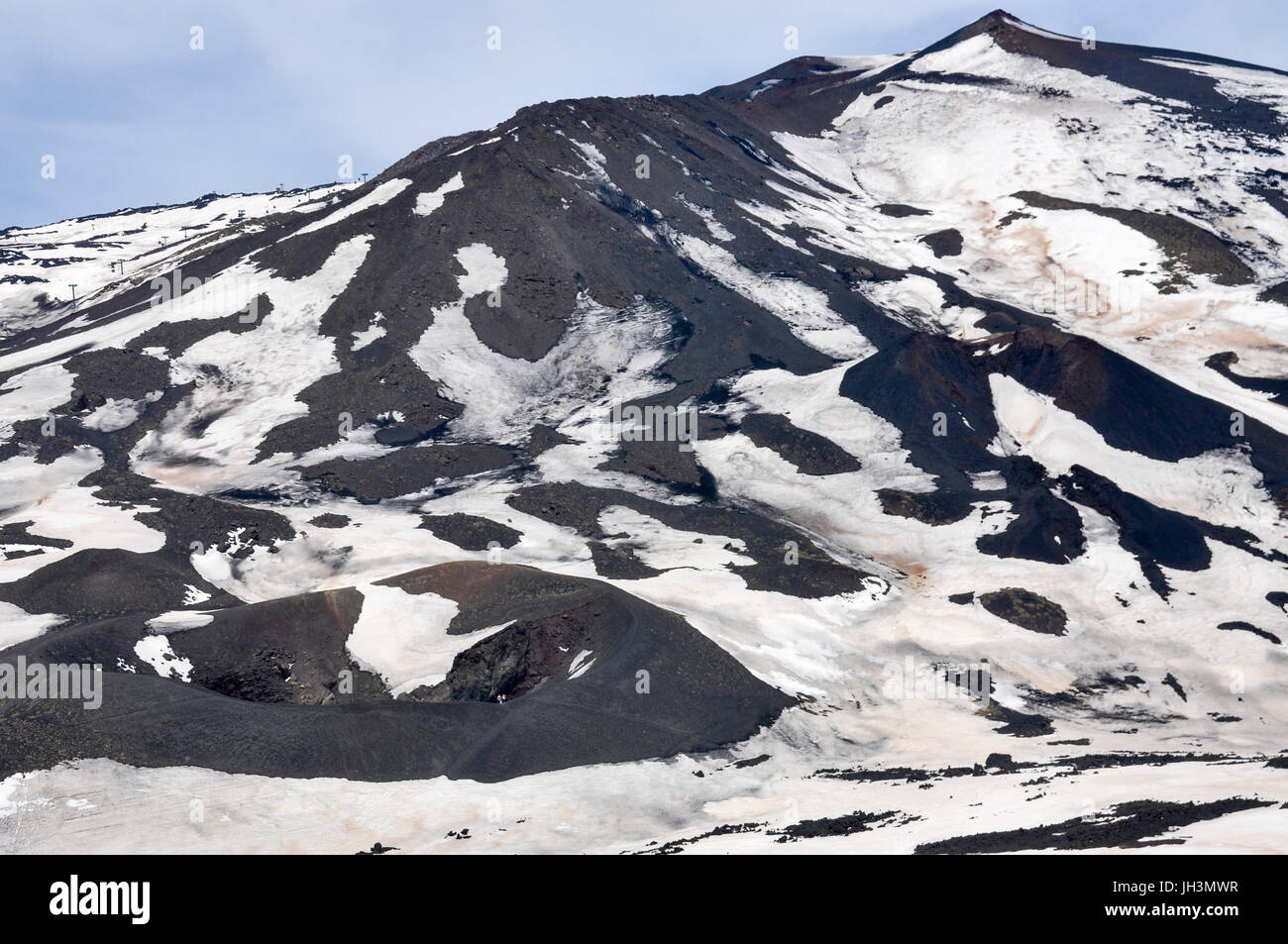 Snow and lava rock on the volcano, Mount Etna, Sicily, Italy. Stock Photo