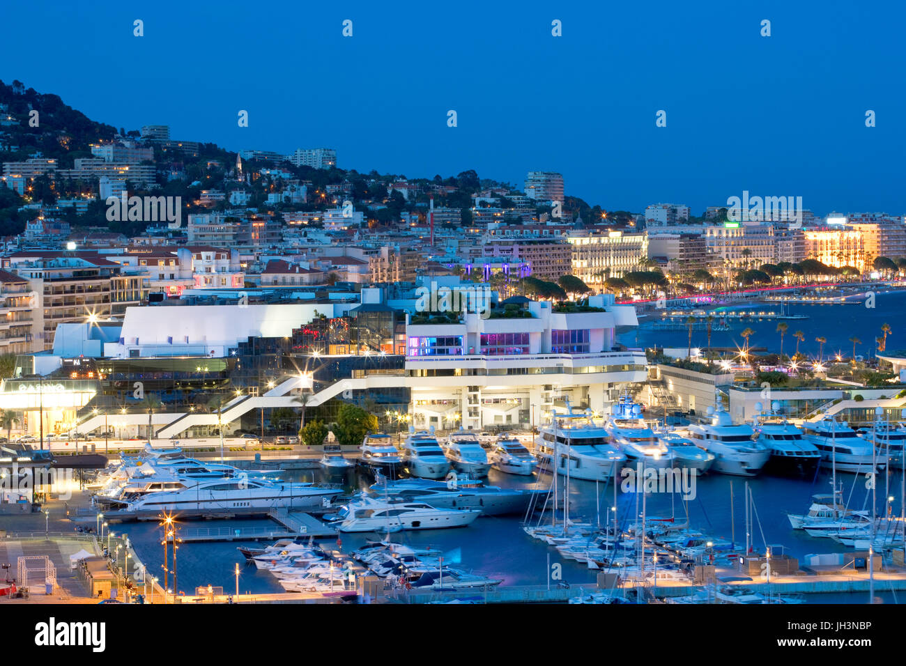 Old port and the Palais des Festivals et des Congrès with la Croisette, Cannes, France at dusk Stock Photo