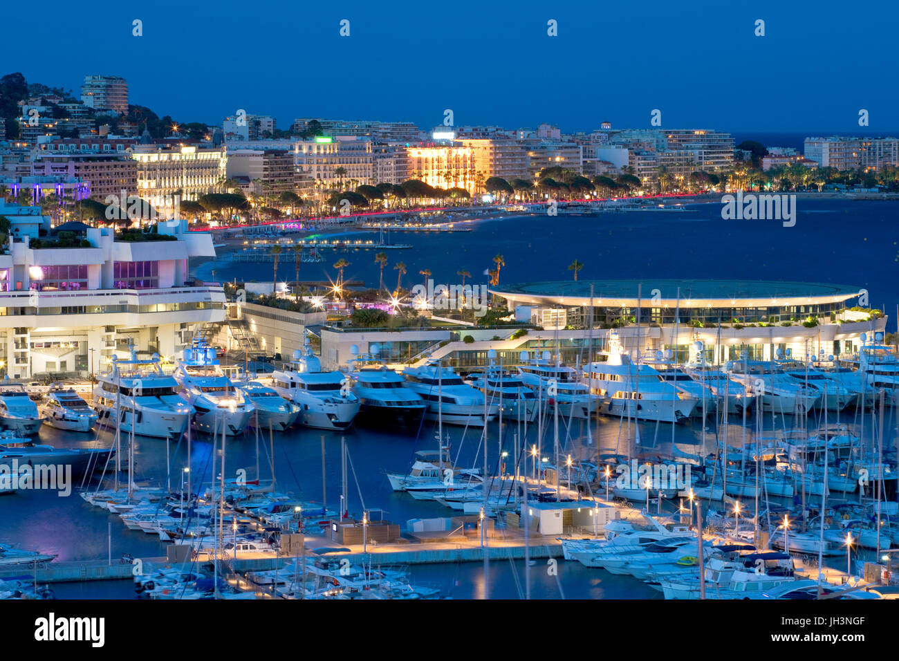 Old port and the Palais des Festivals et des Congrès with la Croisette, Cannes, France at dusk Stock Photo