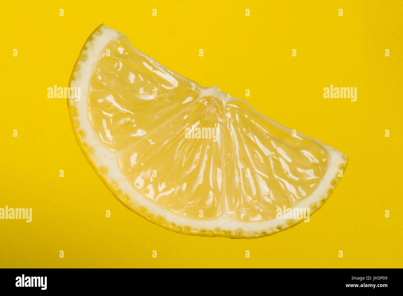 Lemon part on yellow background. Studio shoot. Stock Photo