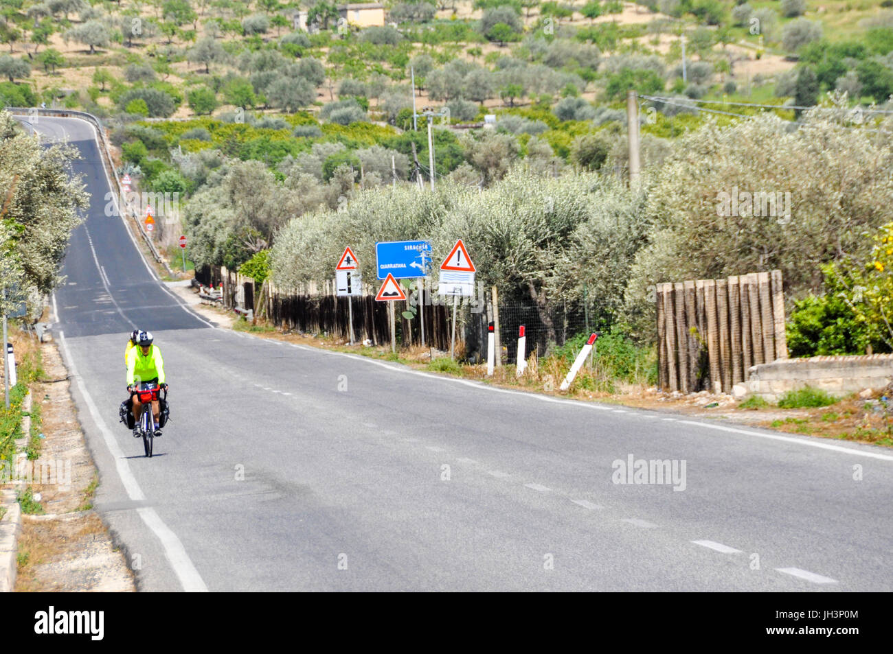 Touring cyclists riding on a country road  in rural Sicily, Italy. Stock Photo