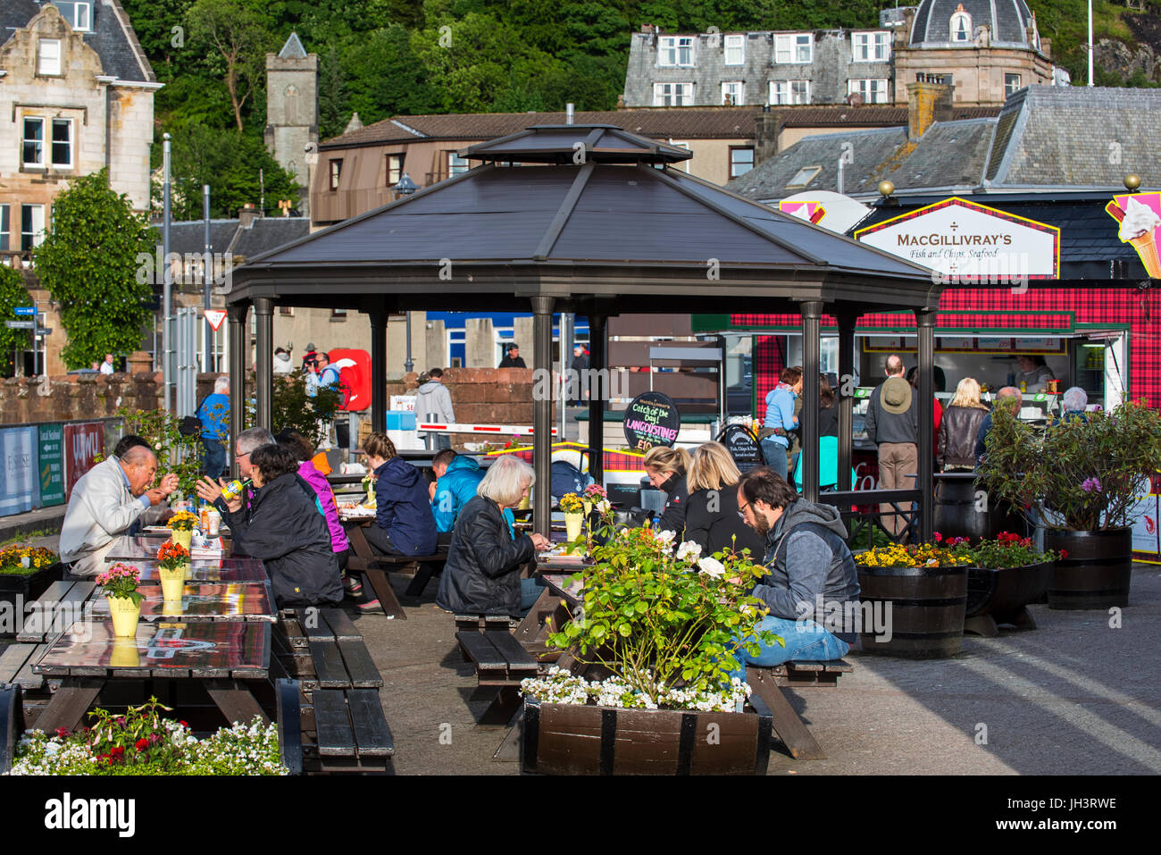 Tourists eating seafood at fish and chips stand in the city Oban, Argyll and Bute, Scotland, UK Stock Photo