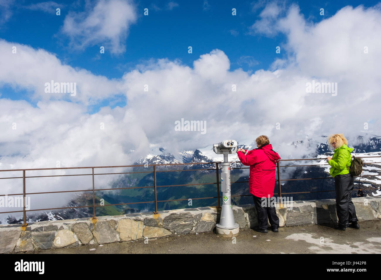 Tourists looking at scenic view from viewing platform on Dalsnibba mountain overlooking Geirangerfjorden. Geiranger Sunnmøre Møre og Romsdal Norway Stock Photo