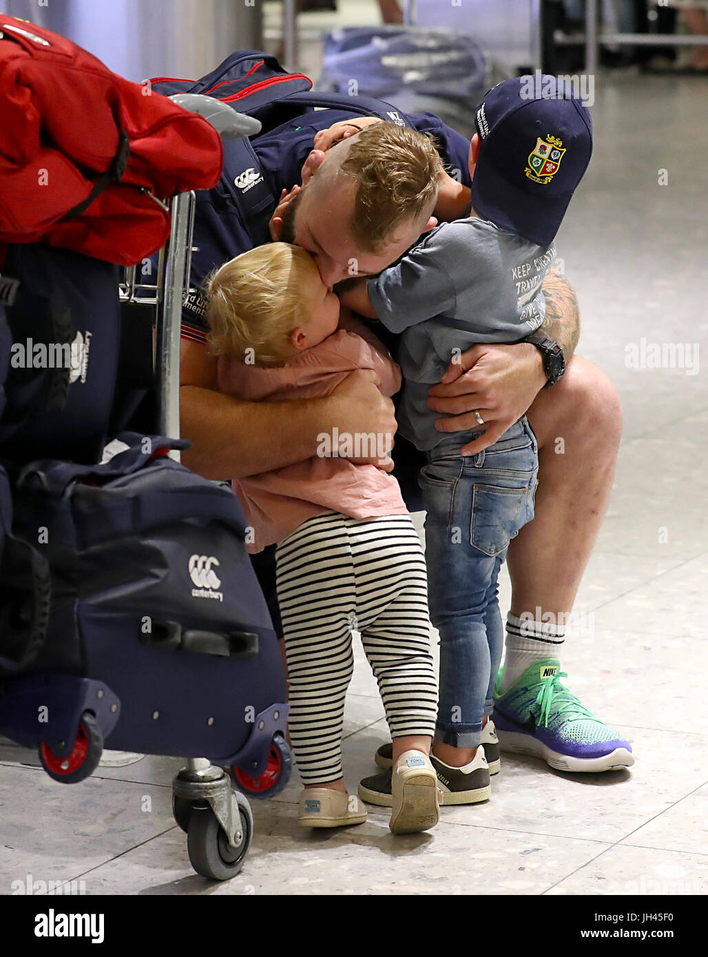 British and Irish Lions Joe Marler greets his children as he arrives at  Heathrow Airport as the British and Irish Lions return to the UK following  their series draw with New Zealand