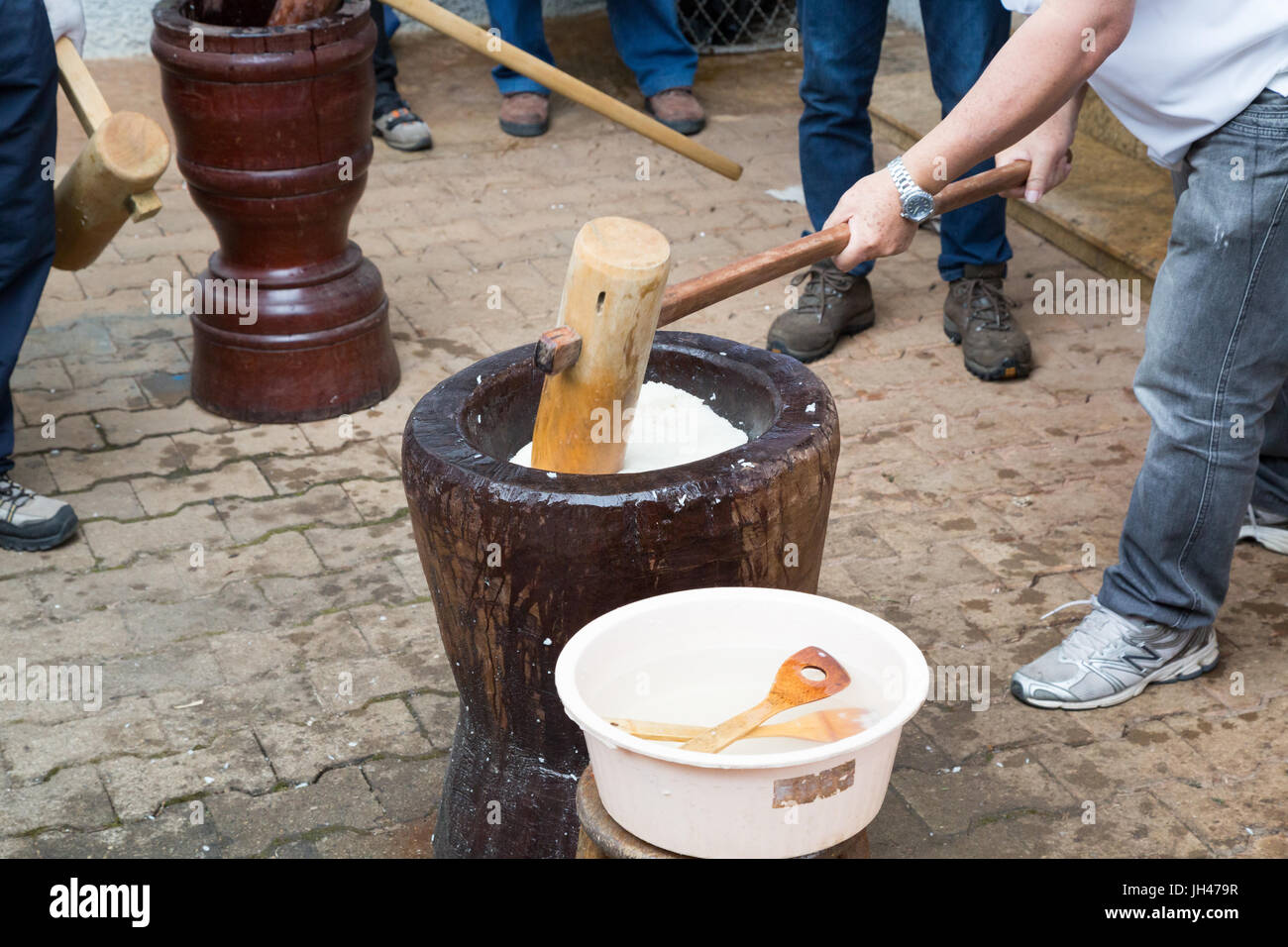 Fresh Japanese mochi being pounded using traditional wooden usu and kine (large mortar and pestle), mochi rice cake made in a ceremony called mochitsu Stock Photo