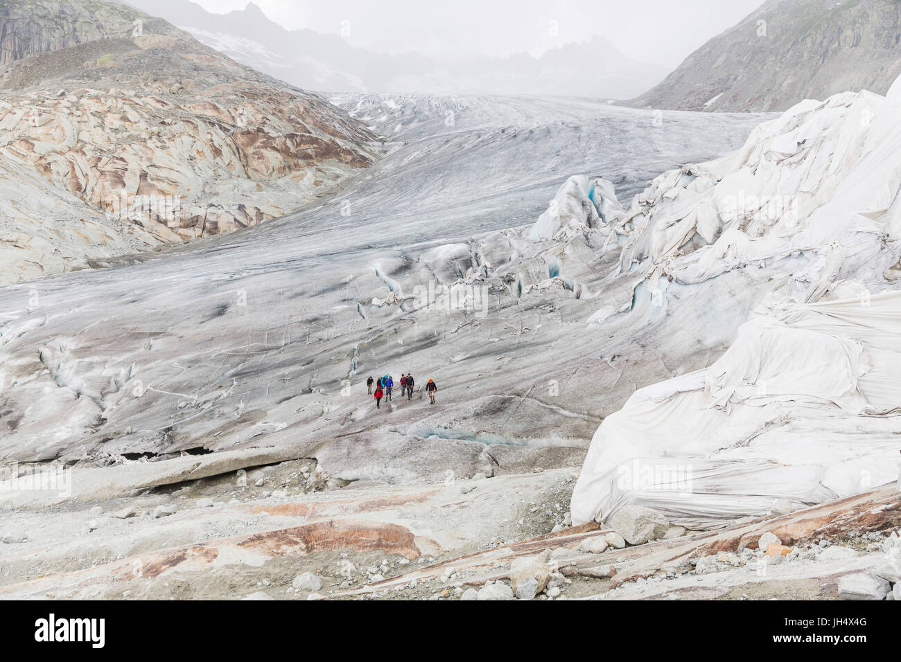 Glacier melt close up: The Rhone glacier is partially squeezed with cloths to slow the melting proc Stock Photo