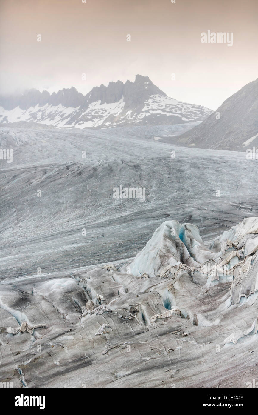Glacier melt close up: The Rhone glacier is partially squeezed with cloths to slow the melting proc Stock Photo