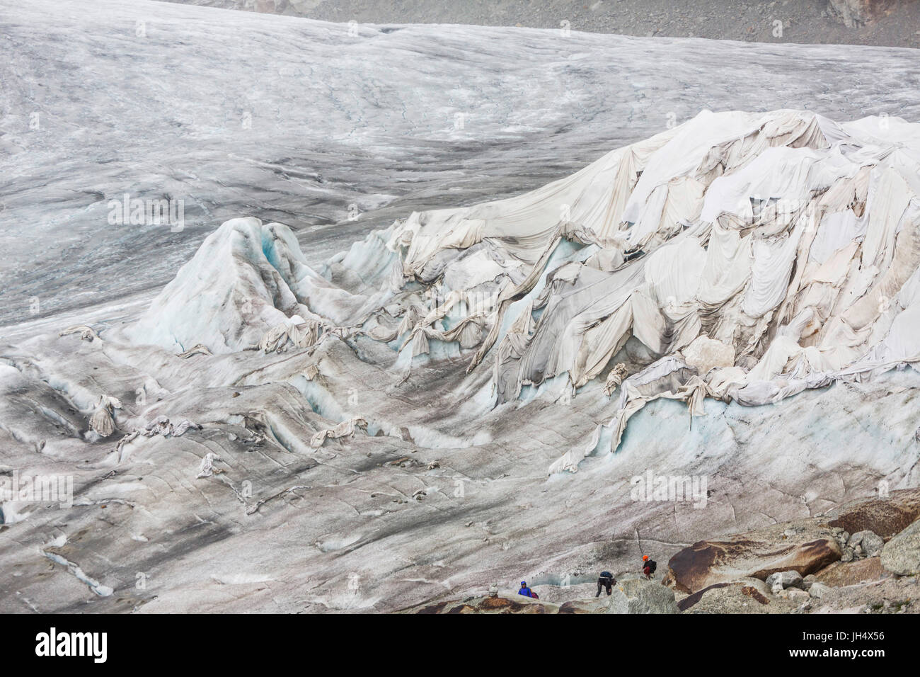 Glacier melt close up: The Rhone glacier is partially squeezed with cloths to slow the melting proc Stock Photo