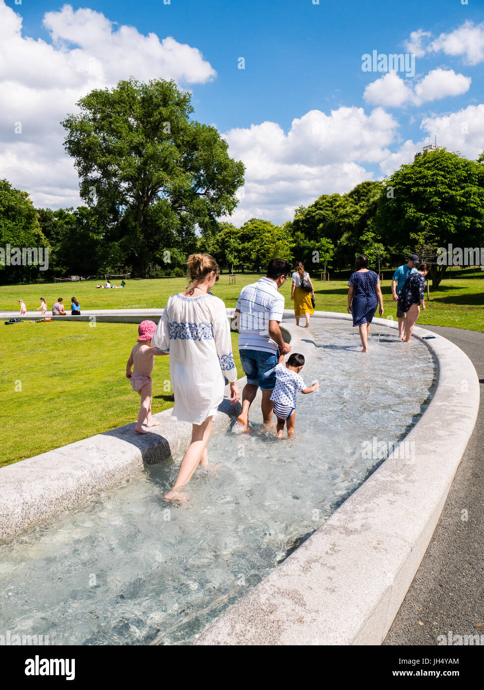 People Enjoying Sunshine, Princess Diana Memorial Fountain, Hyde Park, London, England, UK, GB. Stock Photo