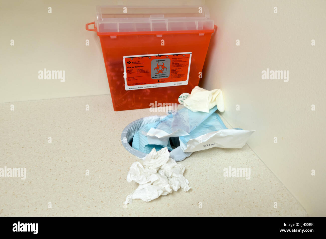 A red bio hazard box with a trash can hole spilling out garbage Stock