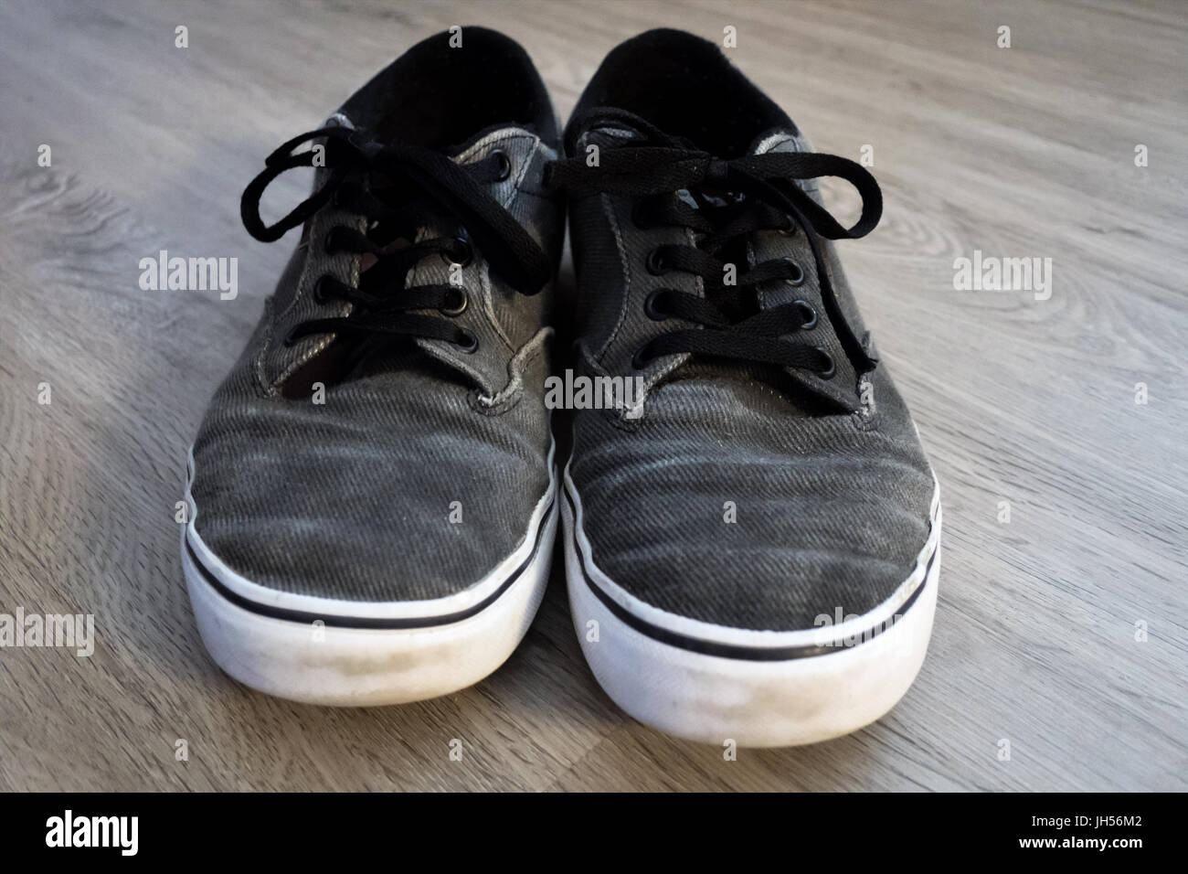 A pair of gray sneakers sitting on a vinyl plank floor Stock Photo - Alamy