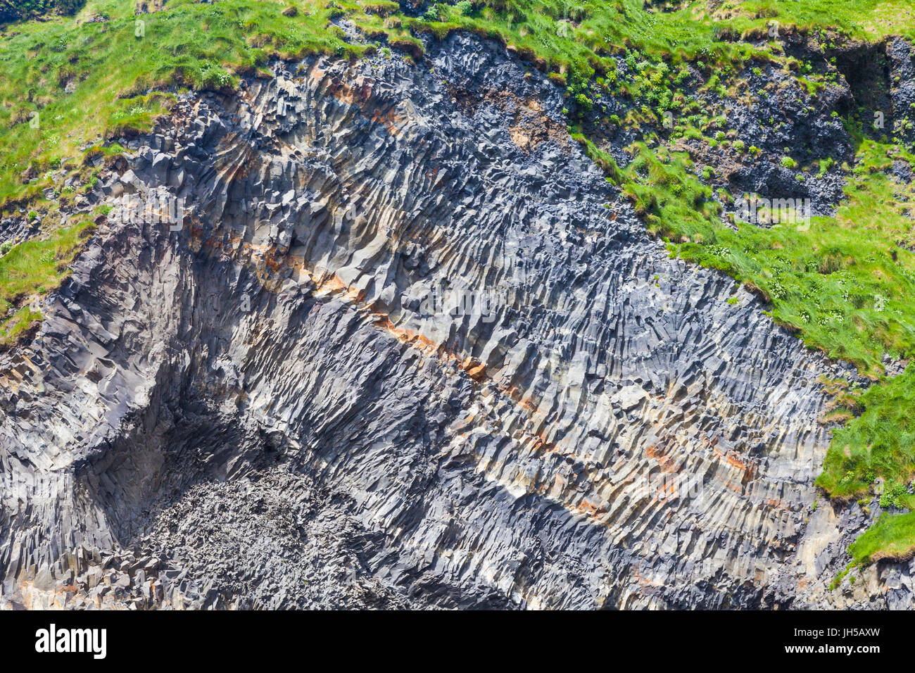 Exposed portion of cliff face showing basalt column formations on Reynisfjara beach in Iceland Stock Photo
