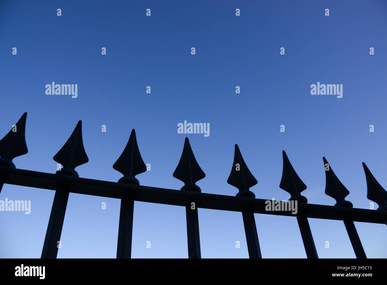 Silhouette view of metal railings against clear blue evening sky. Carmarthenshire. Wales. UK. Stock Photo