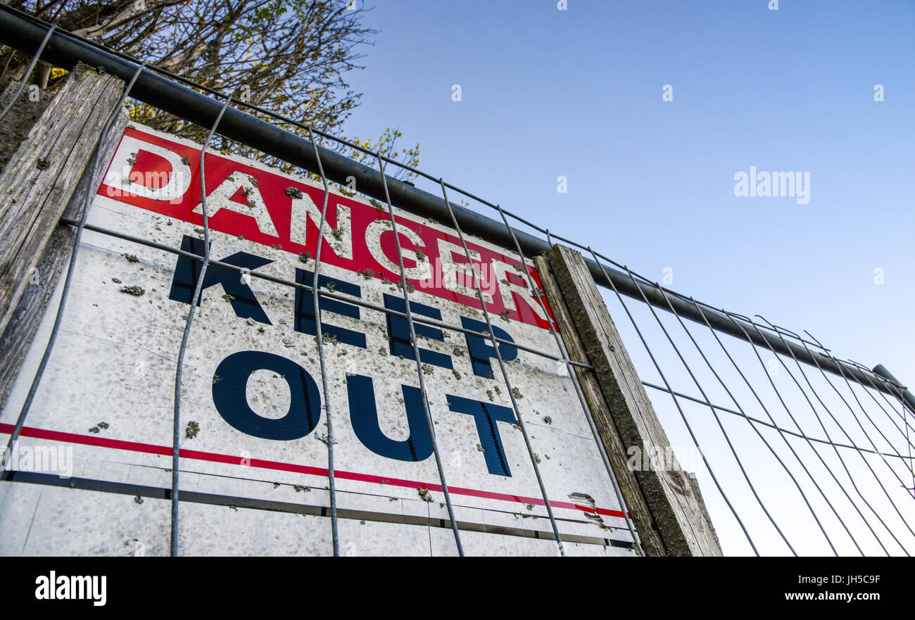 Warning notice mounted to metal fence. Carmarthenshire. Wales. UK Stock Photo